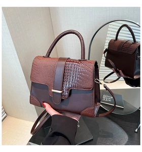 Macro view of vintage brown bag with crocodile texture and magnetic flap detail