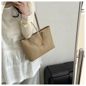 Mirror selfie showing the apricot tote bag with white stitching detail on smooth leather