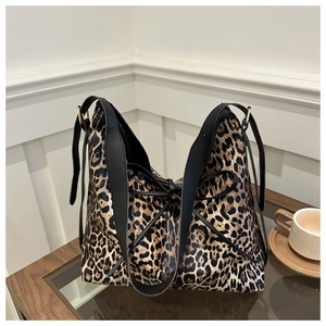 Détail du sac cabas à imprimé léopard avec anses en cuir noir et boucles dorées
