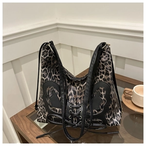 Detail of leopard print tote bag with black butterfly leather patch and lace-up design