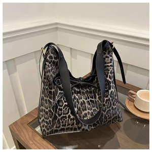 Détail du sac cabas léopard avec nœud noir et larges anses en cuir robuste