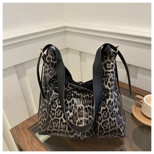 Détail du sac cabas imprimé léopard avec bandoulière noire et nœud décoratif