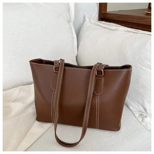 Detail showing high-quality brown PU leather tote with stylish white contrast stitching