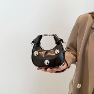 Mini bolso de media luna en cuero marrón oscuro con un adorno de esfera plateada único