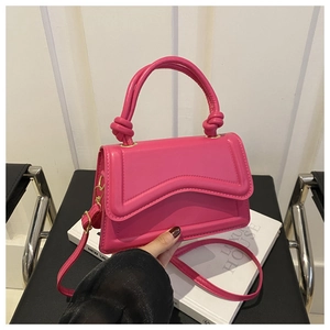 Detail of bright pink mini crossbody bag with wavy stitching and gold metal hardware