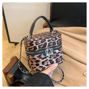 Detailed close-up of leopard print box bag with silver zippers and chain strap