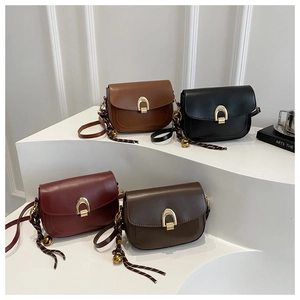 Detail of four retro matte leather saddle bags in brown, black and burgundy on display