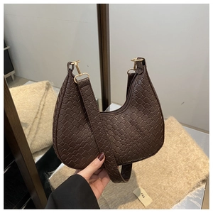 Close-up of dark brown woven crescent hobo bag with gold hardware and matte texture