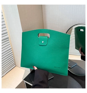Detail view of bright green lychee grain leather handbag with hollow handle and logo