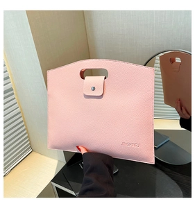 Close-up of pink lychee grain leather tote bag with oval handle and magnetic button