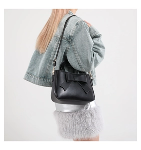 Elegante borsa a mano nera con un grande fiocco mostrata da una vista laterale posteriore