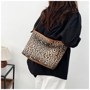 Dettaglio della borsa tote leopardata con cinturini in pelle marrone indossata