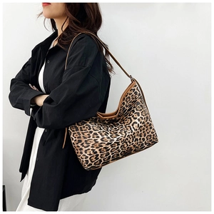 Sac hobo léopard avec bandoulière en cuir marron porté pour un style décontracté