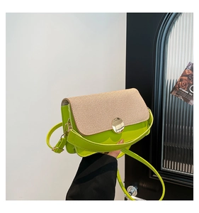 Detail showing neon green crossbody bag with fabric flap and golden round buckle