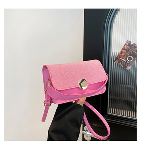 Detail of pink crossbody bag showing striped texture flap and round gold metal clasp