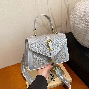 Sac bandoulière en cuir PU tressé argenté avec boucle dorée et sangle jacquard sur bureau bois