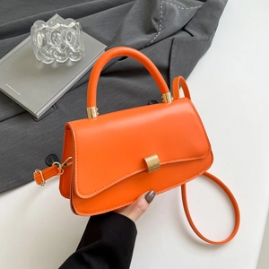 Bright orange crossbody baguette bag in smooth faux leather with gold buckle detail