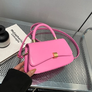 Chic pink leather baguette handbag with gold hardware and adjustable crossbody strap