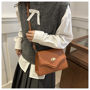 Close-up of a brown vintage leather crossbody bag with a gold metal twist-lock clasp