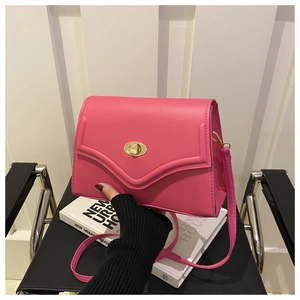 Detailed close-up of rose pink crossbody bag featuring V-shaped stitching and golden twist lock