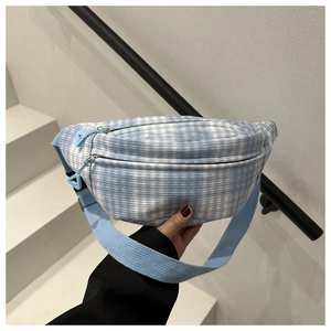 Detail der blau-weiß karierten Brusttasche mit Doppelreißverschluss und Webband
