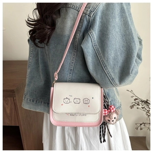 Detail of pink and white crossbody bag with cute animal prints and bear charm
