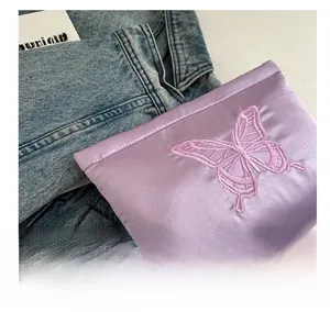 Close-up of lavender satin bag featuring exquisite pink butterfly embroidery detail