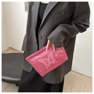 Detail of rose pink satin evening clutch featuring intricate large butterfly embroidery