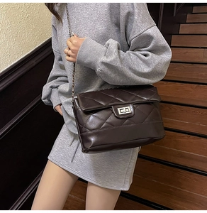 Détail du sac bandoulière matelassé marron foncé avec chaîne et fermoir rotatif