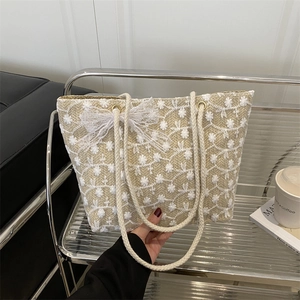 Lace straw tote bag with white flower embroidery and ribbon bow for summer beach