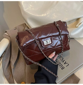 Détail du sac en cuir matelassé bordeaux avec chaîne argentée et fermoir rotatif
