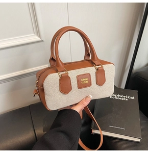 Detail of vintage Boston bag featuring canvas leather patchwork and golden hardware accents