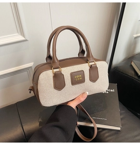 Close-up of vintage Boston bag with brown leather and beige textured woven stitching