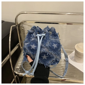 Vue détaillée du sac seau en jean bohème avec broderie d'étoiles et bords effilochés