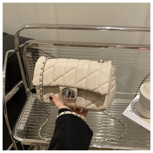 Detail view of quilted leather bag with silver chain strap and metal swivel lock