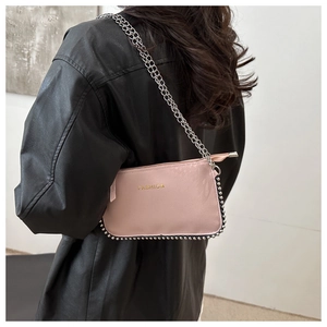 Pink leather crossbody bag with silver beaded trim and fashion logo detail on shoulder