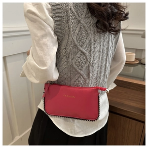 Detail of fuchsia chain crossbody bag with pebble texture and metallic bead trim