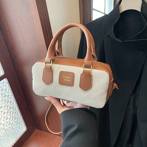 Vintage canvas and brown leather mini Boston bag shown in a lifestyle handheld view
