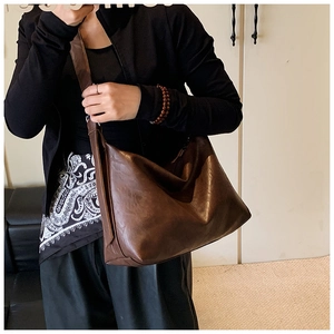 Detailed view of deep brown vintage tote bag with wide strap and grainy leather texture