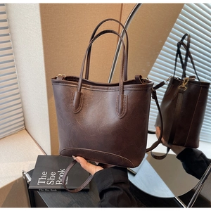 Detail view of deep brown vintage bucket bag with retro texture and adjustable strap