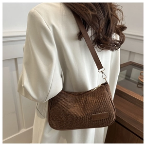 Close-up of retro canvas handbag showing brown woven texture and leather piping details