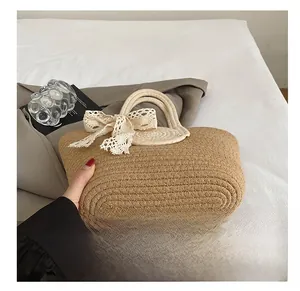 Close-up of durable woven bottom on a straw tote bag with a white lace bow detail