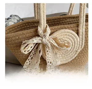Detail shot of straw woven tote bag featuring white lace bow and intricate texture