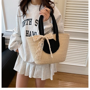 Sac fourre-tout en paille avec poignées en corde noire et nœud en dentelle sur mannequin