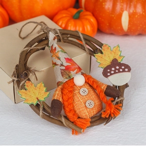 Detail of harvest gnome wreath featuring knitted braids and maple leaf felt acorn decoration