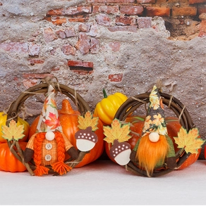 Detail of fall harvest gnomes on rattan wreaths with maple leaves and acorn decor