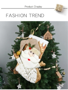 Detail of a 3D Santa plush Christmas stocking with gold sequins hanging on a tree