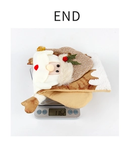 Detail shot of a plush 3D Santa Christmas stocking being weighed at 116.2g on a scale