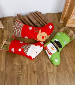 Set van drie kerstkousen met kerstman, rendier en sneeuwpop op een houten vloer