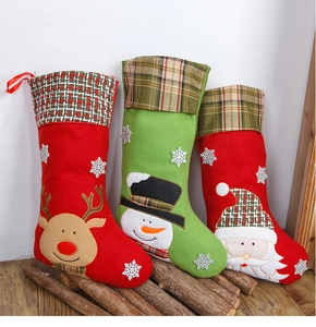 Details van drie geborduurde kerstsokken met rendier, sneeuwpop en de kerstman